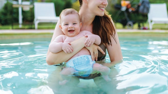 Best swim diapers - parent holding baby above the water in a pool