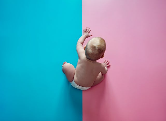 Baby sitting on a blue/pink surface
