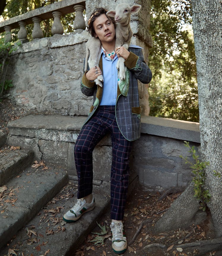 Harry Styles poses for Gucci wearing fashion similar to the Gucci HA HA HA collection.