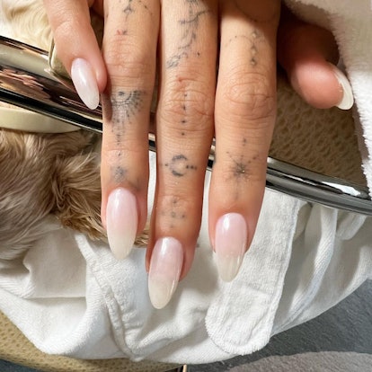 Hailey Bieber's glazed donut nails, as shown in a pearlescent baby pink polish shade.