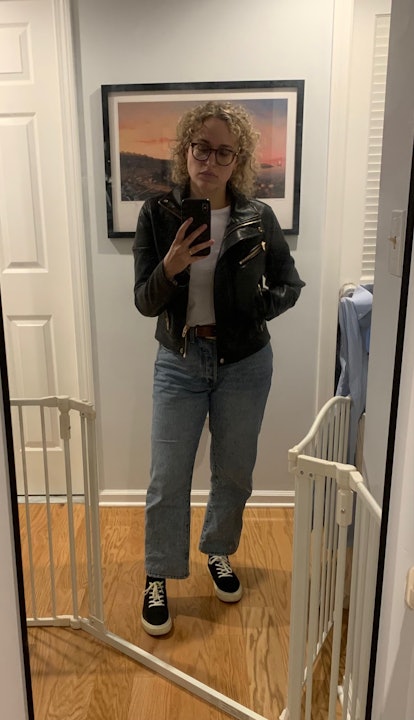 a woman in leather jacket, straight jeans, and black sneakers