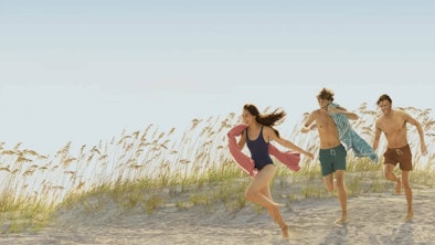 Belly, Jeremiah, and Conrad running on the beach in 'The Summer I Turned Pretty'.