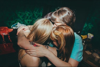 The Los Bitchos band members in a group hug before the show