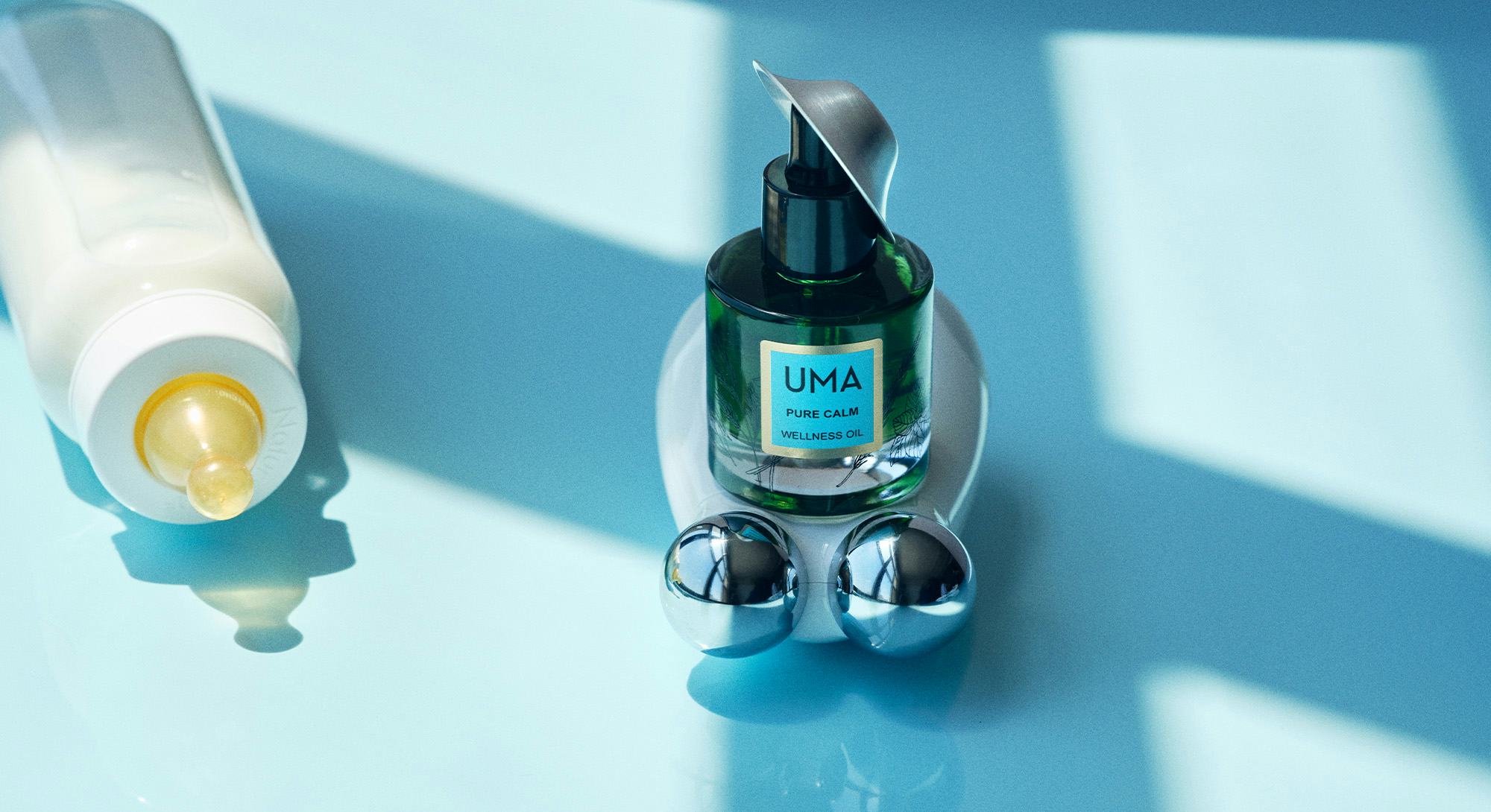 A beauty device for pregnant women, along side Uma pure calm wellness oil and a baby bottle