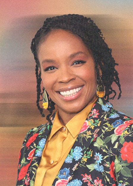 Amber Ruffin in a yellow button down and floral print suit, smiling 