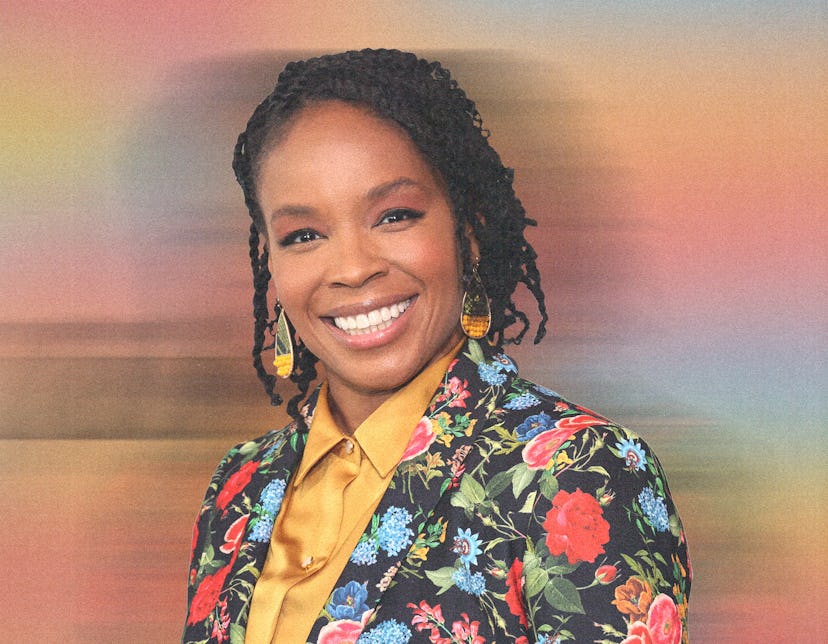 Amber Ruffin in a yellow button down and floral print suit, smiling