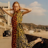 the model Rianne van Rompaey wearing a colorful dress on a coastal road in Japan