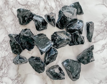 Flat lay of raw black obsidian healing protective crystals