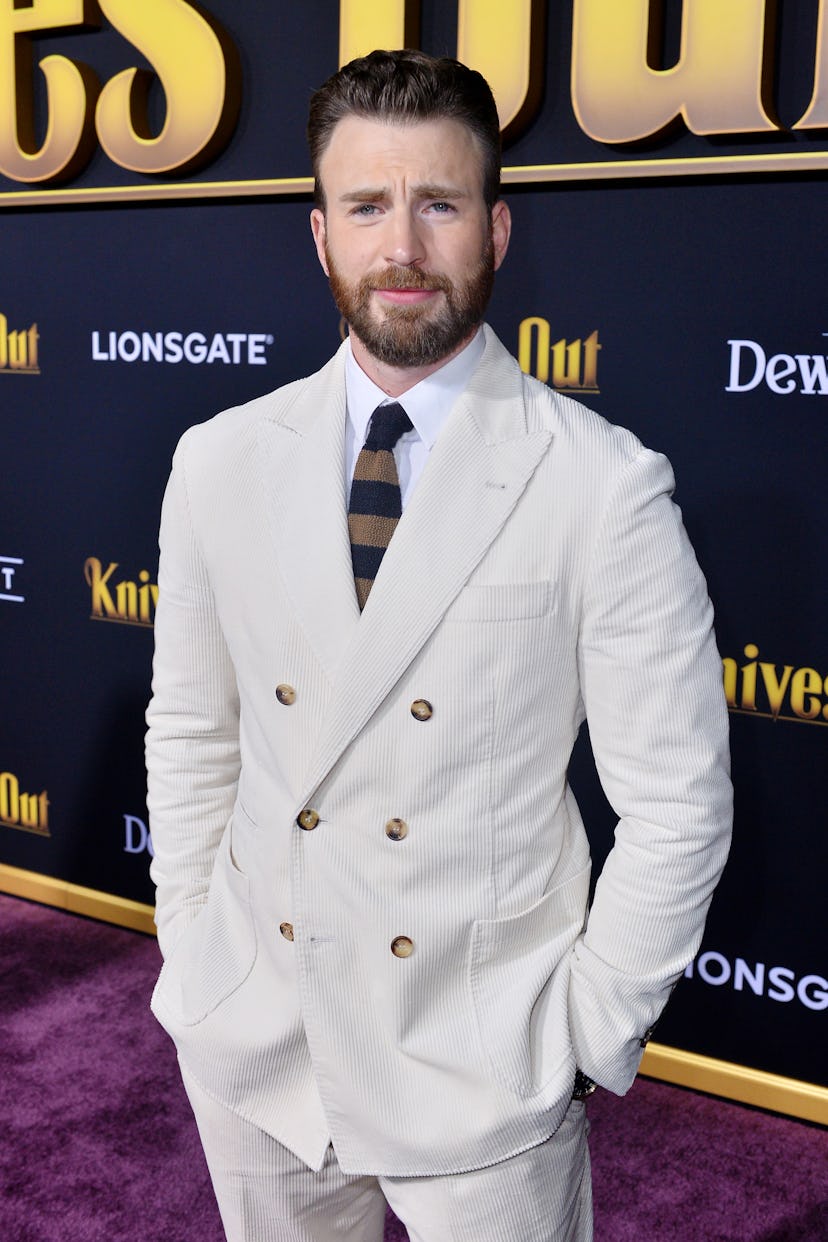 Chris Evans wearing a light tan suit on a red carpet