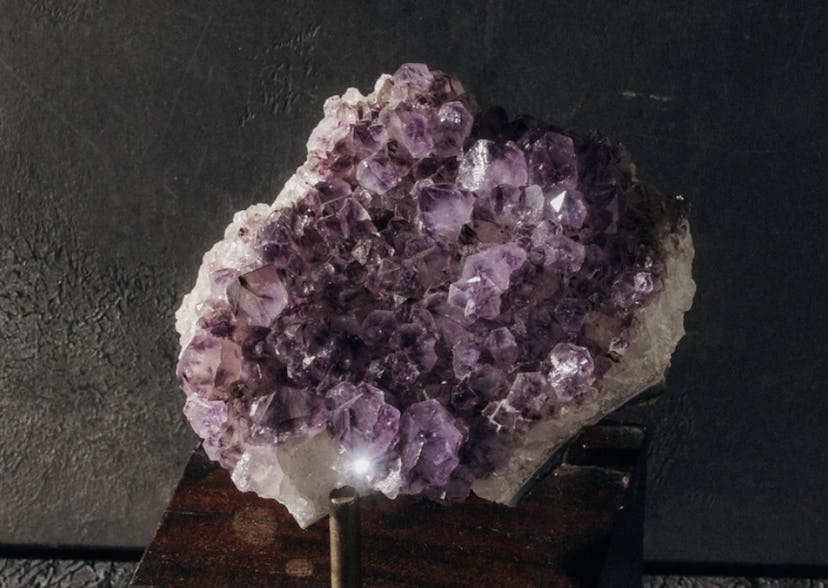 Amethyst cluster, a crystal for empaths, on a stand