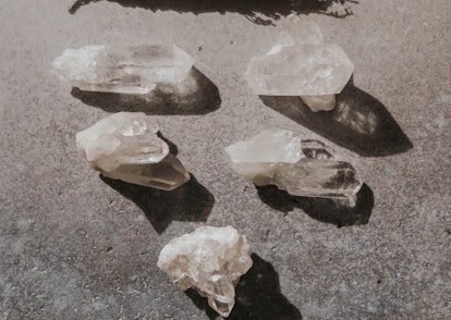 Five clear quartz crystals, a crystal for empaths, on a stone floor
