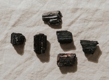 Six black tourmaline stones, a crystal for empaths, on a cloth