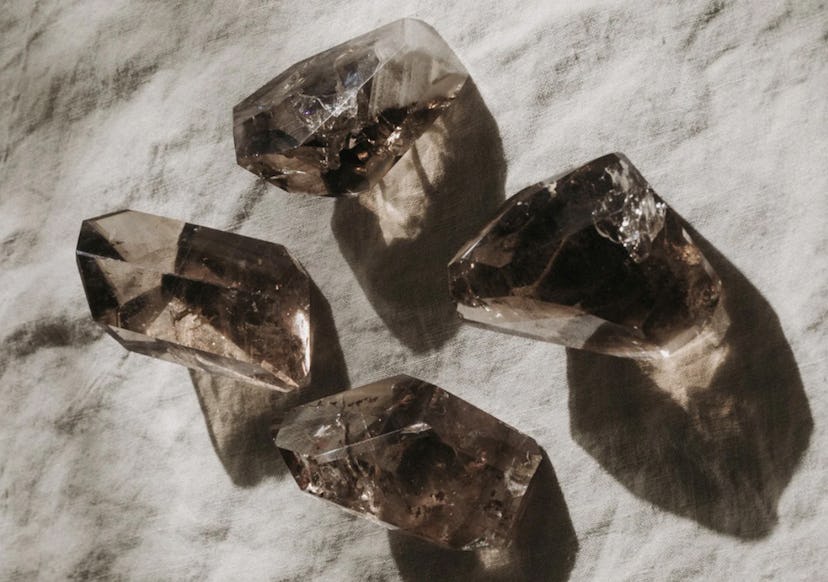 Four smokey quartz crystals, great for empaths, on a cloth