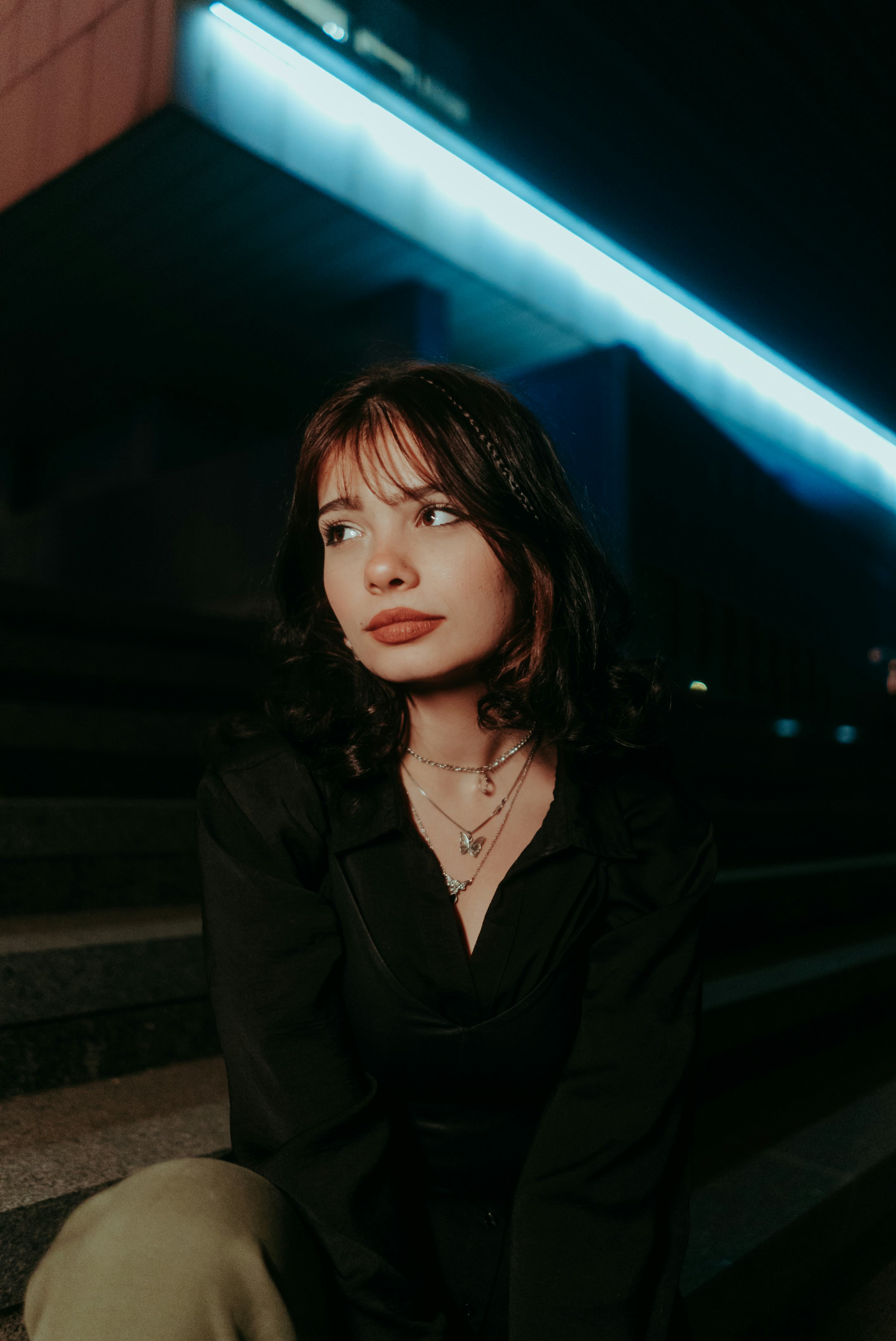 Young woman surrounded by blue neon lights during Neptune retrograde 2022.