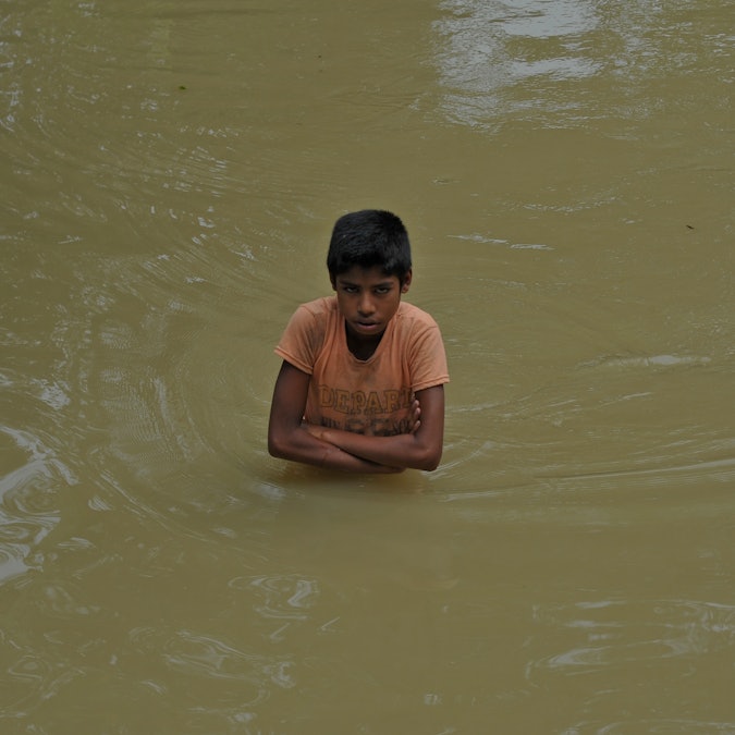 Boy standing in floodwaters in Bangladesh