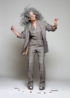 A portrait of Lorraine Massey dancing with her curly hair, and scissors in hand
