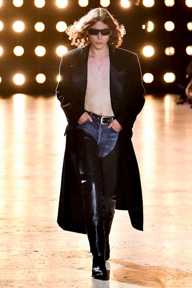 A shirtless model wearing sunglasses on the Celine spring 2023 menswear runway
