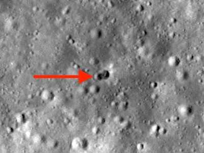 Crater image with a red arrow pointing at the site of a rocket booster crash