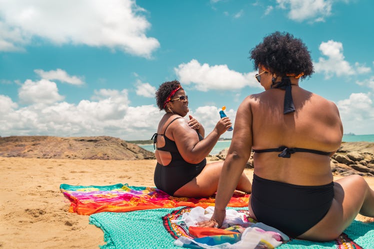 2 friends hanging out at the beach after reading their zodiac signs' July 2022 horoscope.