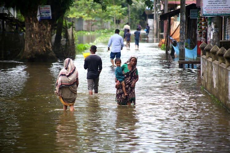 People wading through floodwaters in Bangladesh