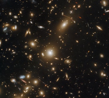 Photo of dozens of spiral galaxies at various angles against the darkness of space.