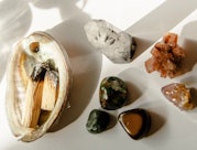 Abalone shell with burning palo santo incense next to an assortment of healing crystals. Here's how ...