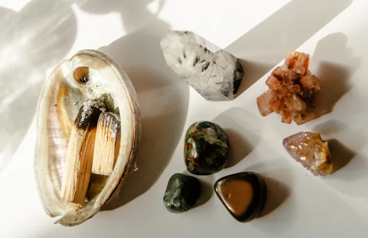 Abalone shell with burning palo santo incense next to an assortment of healing crystals. Here's how ...