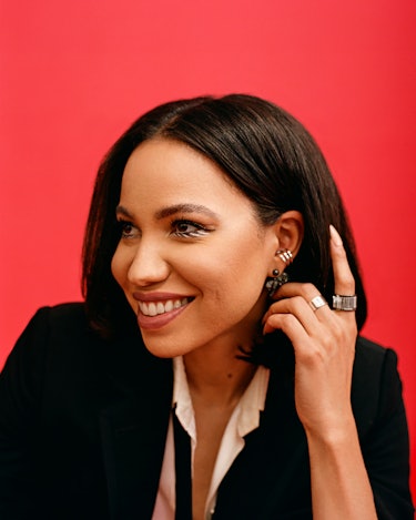 Jurnee Smollett in a black suit and white shirt pushing her hair back with one hand, displaying her ...