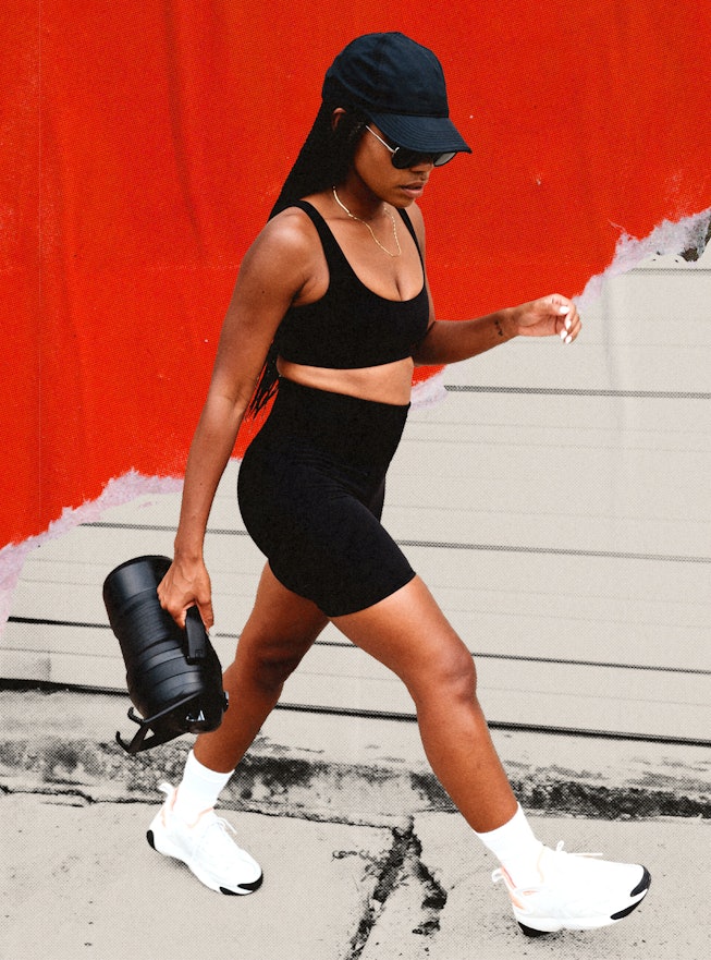 A girl in a black gym outfit and a baseball hat doing a “Hot Girl Walk”