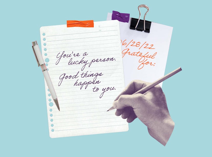 A hand writing manifestations with a pencil in a notebook