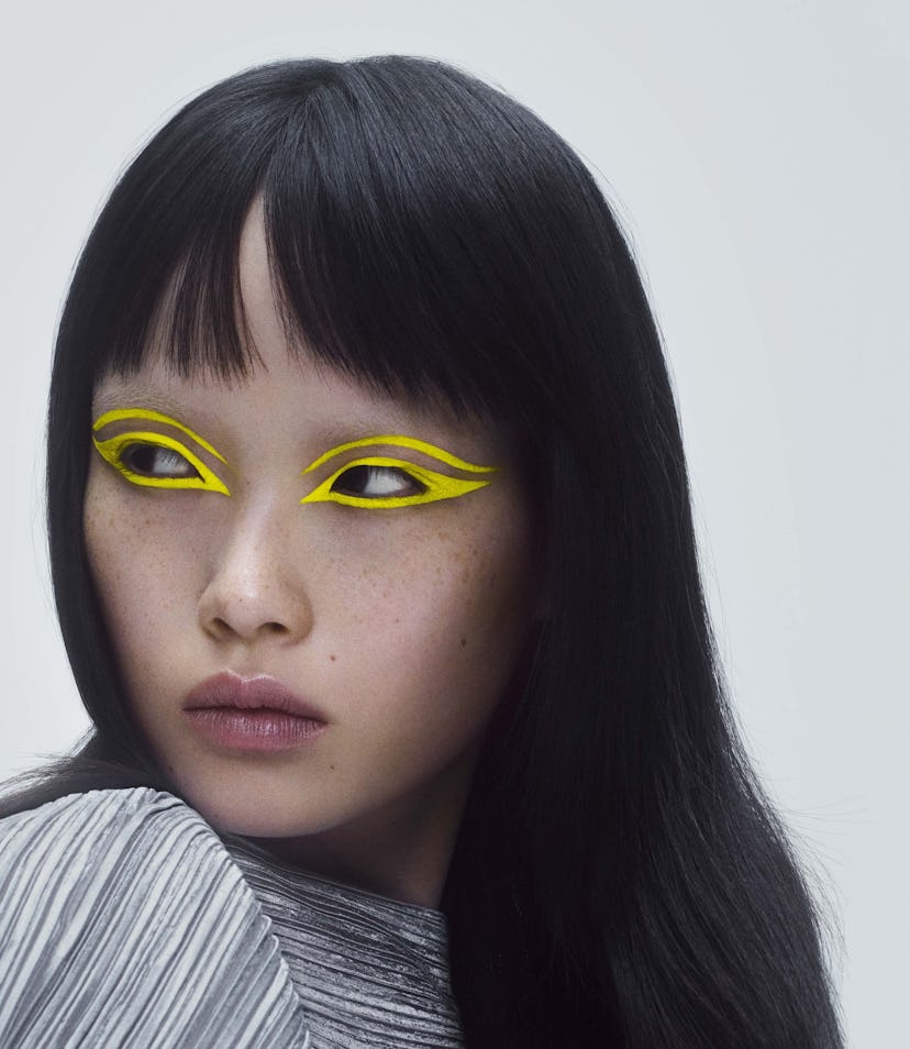 A model wearing a bright yellow eyeliner makeup look.