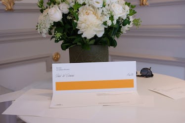 Comedian Paul W. Downs Shares His First Fashion Show Experience 3 An Hermes fashion show invitation sitting on a table with some white flowers