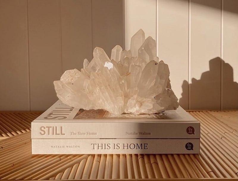 Clear quartz crystal cluster on a stack of coffee table books. Clear quartz is a protection crystal ...