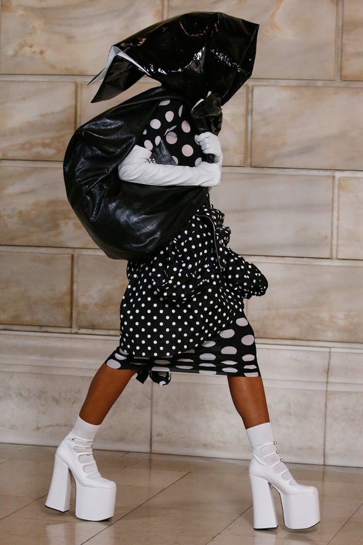 Model on the NY Fashion Week Fall 2022 runway in a Marc Jacobs black dress with white spots, white h...