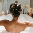 A woman sits in the bath using Wiley Body products. Wiley Body is a beauty brand donating to Abortio...