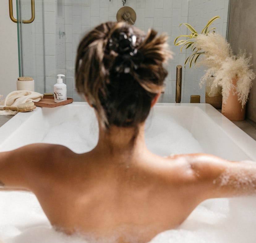 A woman sits in the bath using Wiley Body products. Wiley Body is a beauty brand donating to Abortio...