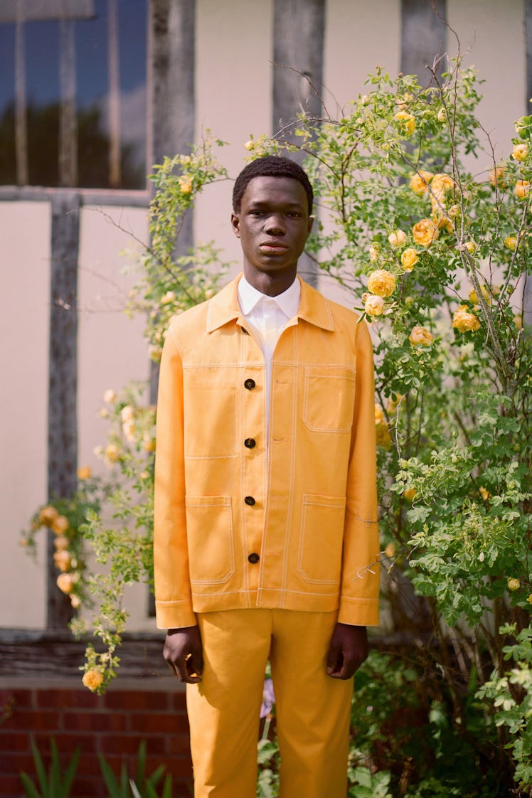 A model wearing an orange suit and a white shirt by Erdem 