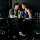 Couple drinking in a booth while asking fun questions to help learn more about their partner.