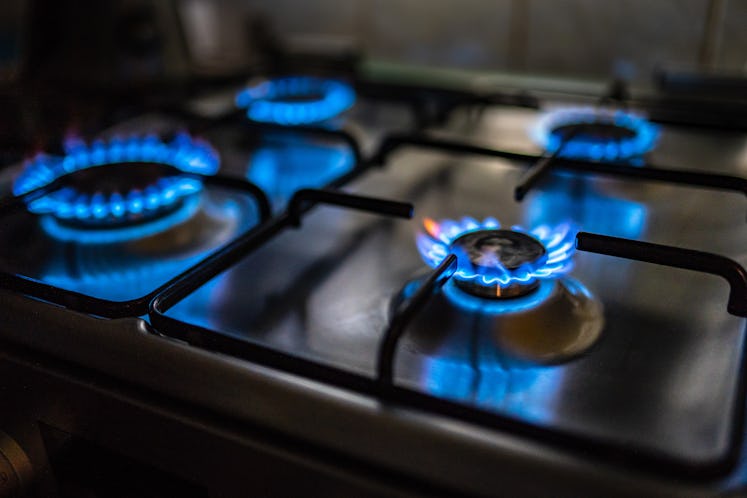 A gas stove with all four burners lit.