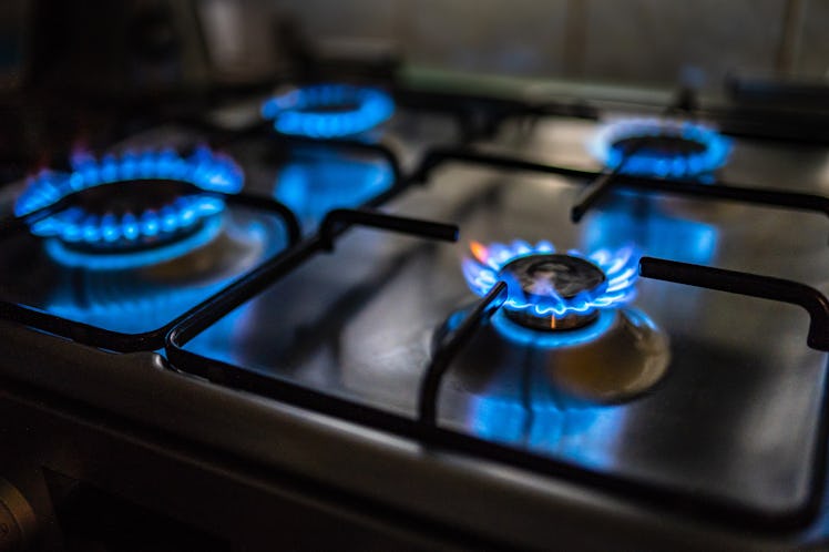 A gas stove with all four burners lit.