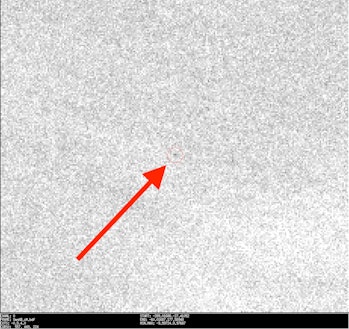 red arrow pointing to a small red circle, within which is a speck representing a meteorite
