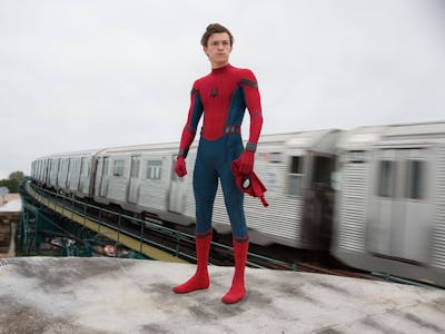 Tom Holland as Spider-Man from the MCU standing on the concrete block while a train is passing next ...