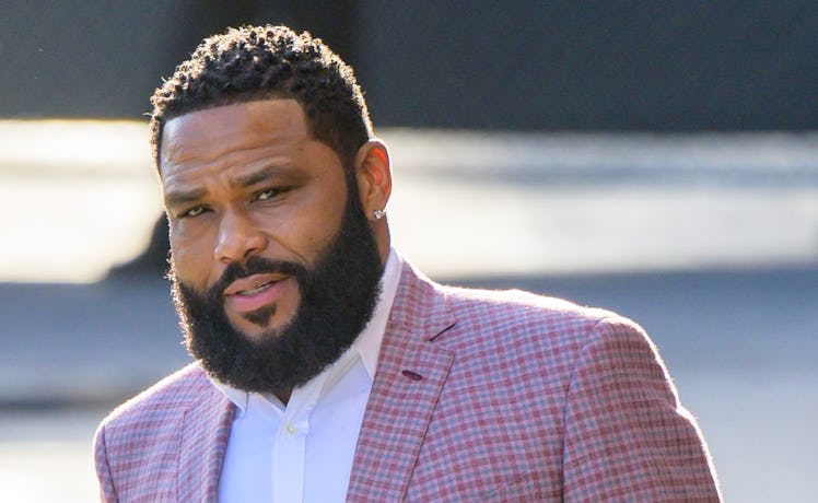 Anthony Anderson walking in a red blazer with a short haircut and big beard