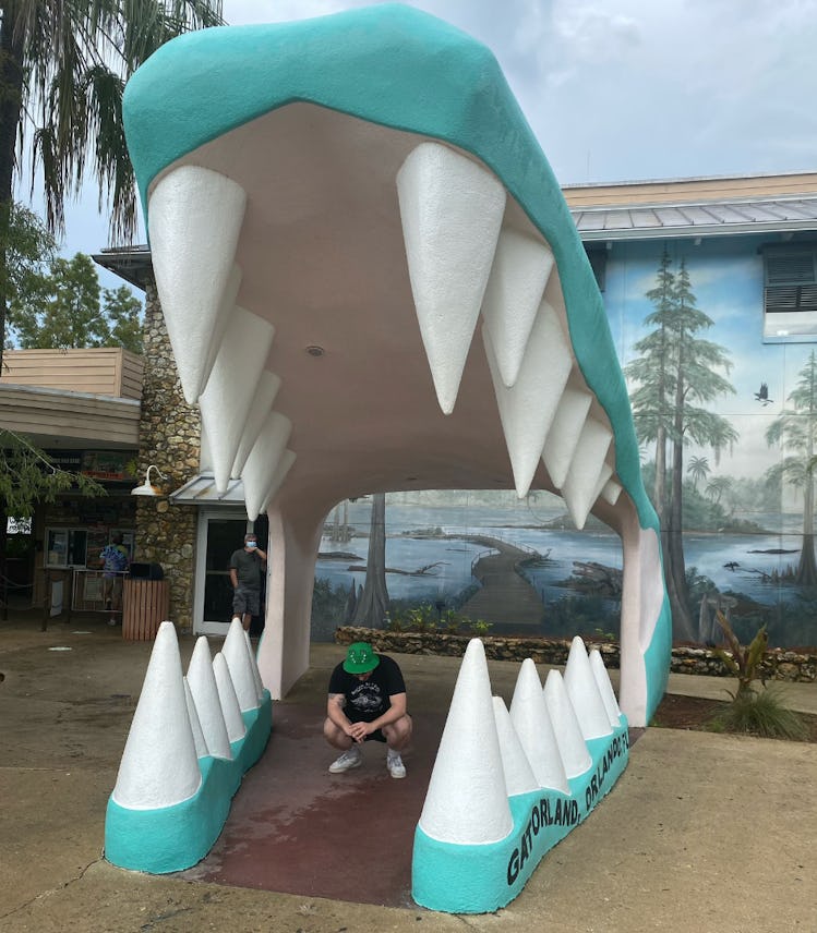 Photo of Seth Kaplan of Gators Daily next to an alligator enclosure