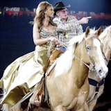 Beyonce on a horse with a nice man helping her in Houston.