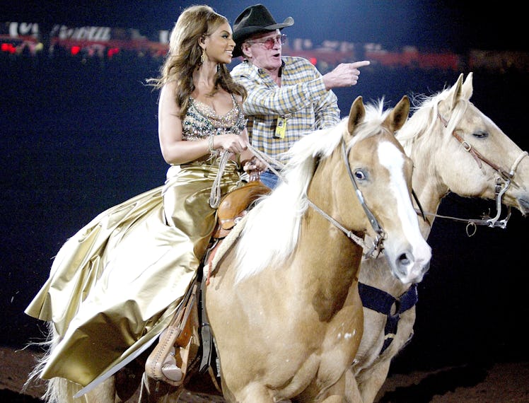 Beyoncé rides a horse in Houston with the help of a guide wearing a cowboy hat.