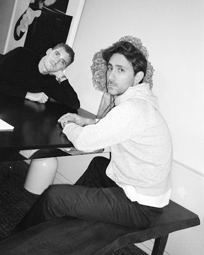 Kevin and Charles sitting at a table looking at the camera