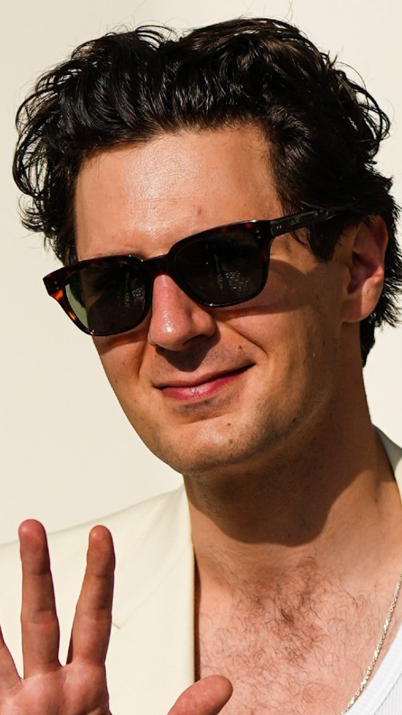 A man wearing a white blazer and black sunglasses