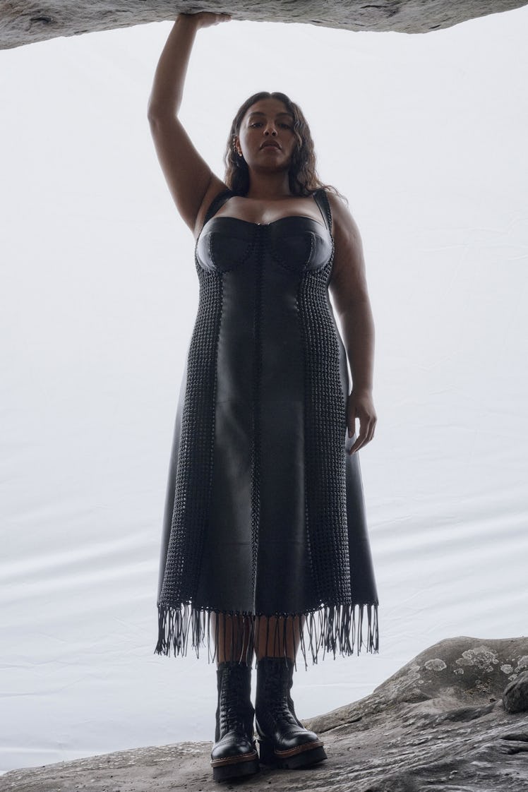 A woman posing in a grey Chloé dress on a cliff