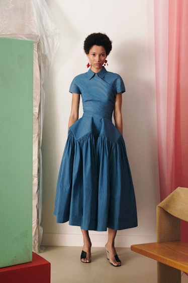 A female model posing in a Tory Burch blue dress